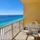 table with outside seating on balcony with water and beach view